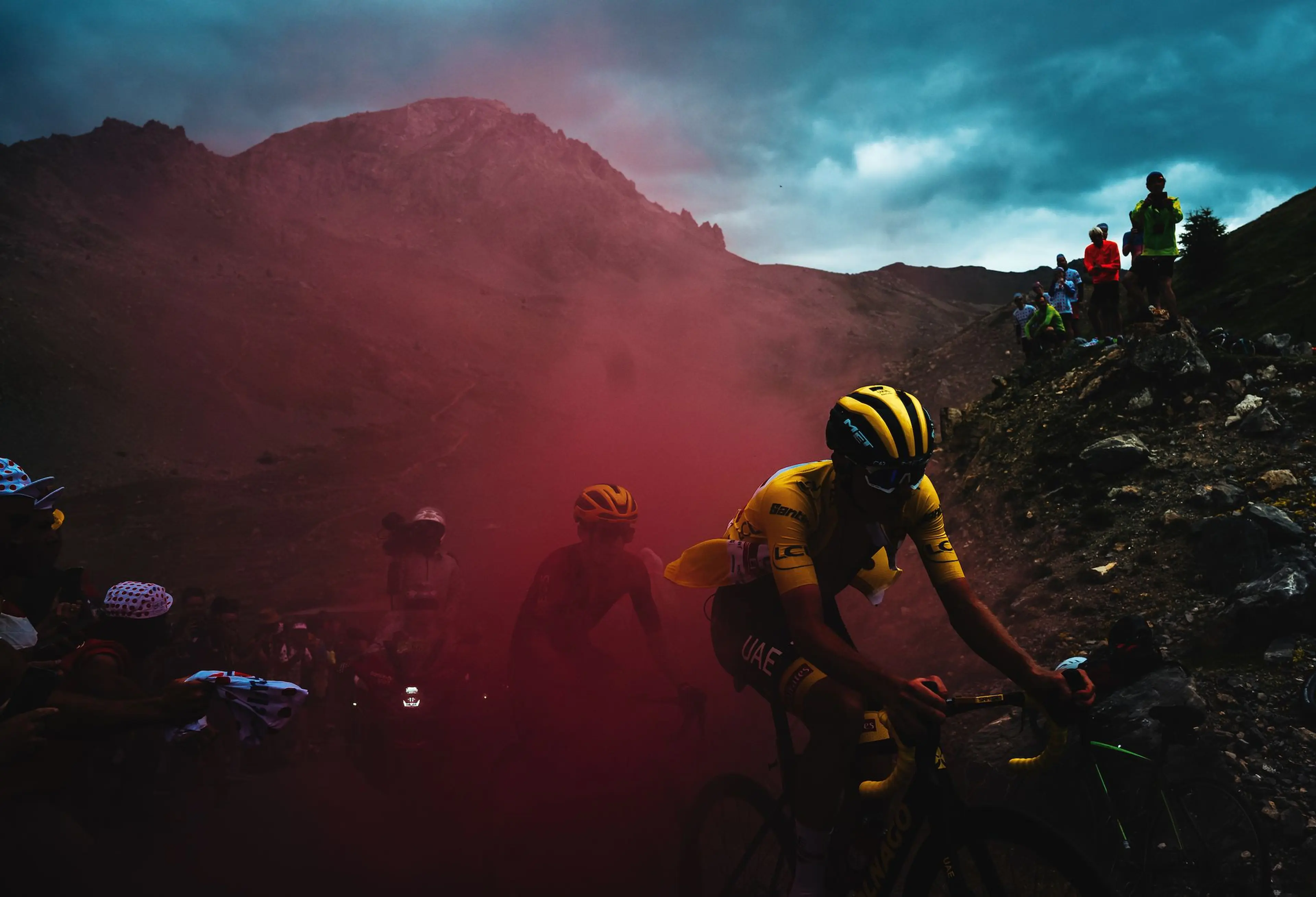 Tadej Pogačar rides through smoke set off by a fan while climbing the Granon on Stage 11. Pogačar lost several minutes to Jonas Vingegaard on the stage and would give up the yellow jersey.